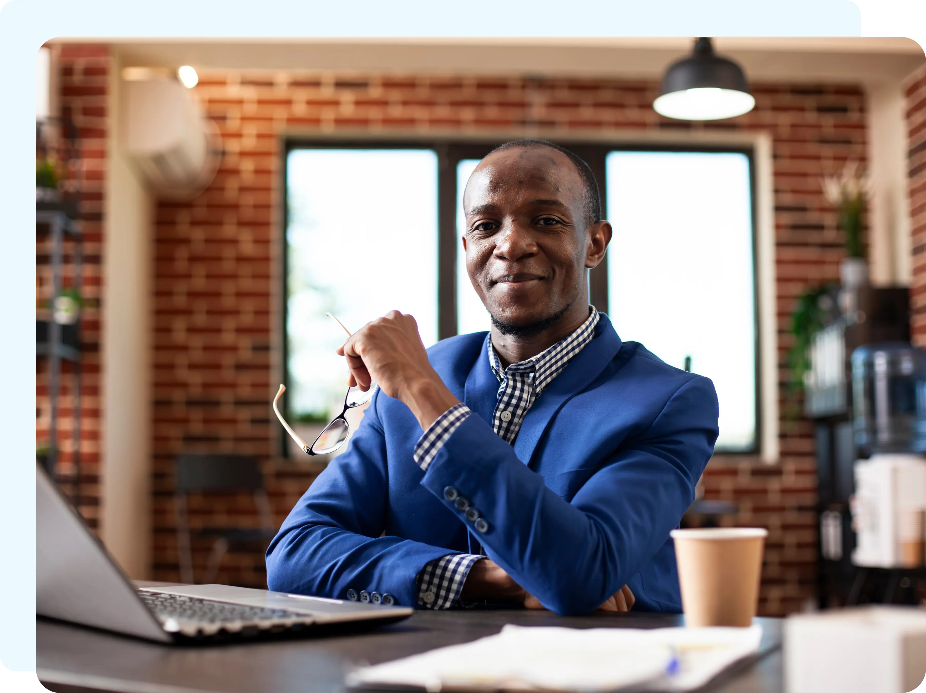 A smilling man in front of a computer monitor